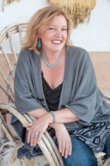 Photo of author Natalie Bovis sitting in an outdoor chair and smiling at the camera